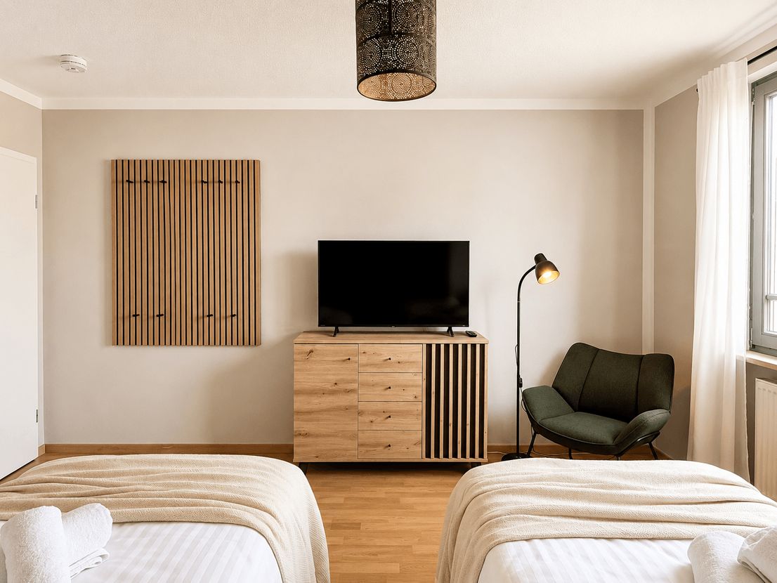 Zweites Schlafzimmer mit zwei Betten und stimmungsvoller Beleuchtung in der möblierten Wohnung Dresden-Zschertnitz